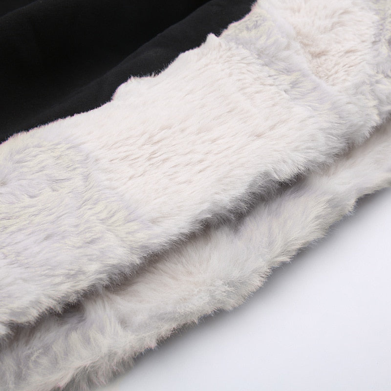 Black holiday mini dress with white fluffy cuffs and hem with a close view of the fluffy white hem trim.