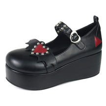 Black Winged Heart platform shoe shown from a three-quarter angle, with red heart decoration, silver-tone studs and heart-shaped buckle visible.