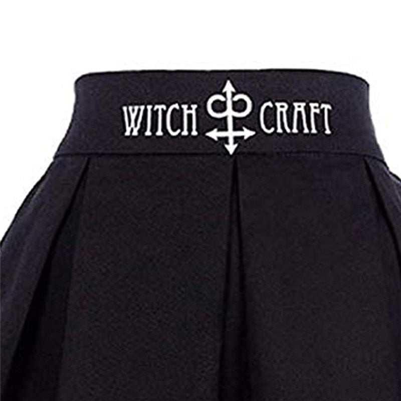 Close view of the black skirt waistband with white Witch Craft lettering and a central ornamental symbol.