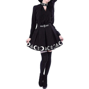Full outfit view of the black Witch Craft skirt, with the hem held out above thigh-high stockings and black shoes.