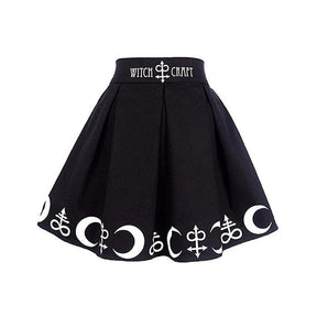 Black Witch Craft skirt displayed alone with deep pleats, a wide lettered waistband and white crescent motifs.