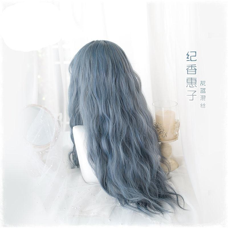 Rear view of the blue-gray wig worn loose, showing long waves and the blend of smoky blue and gray tones against a white decorative background.