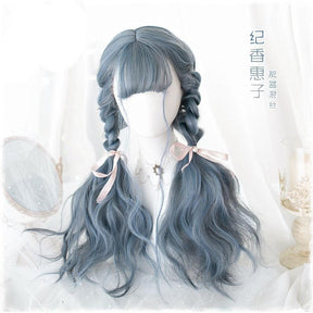 Long blue-gray wig styled with two braids that lead into loose waves, finished with pale pink bows. The mannequin has a straight fringe, with supplier lettering printed over the photo.