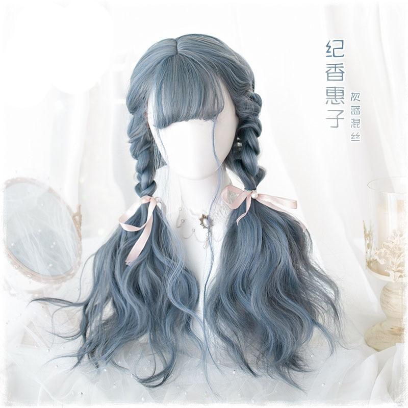 Long blue-gray wig styled with two braids that lead into loose waves, finished with pale pink bows. The mannequin has a straight fringe, with supplier lettering printed over the photo.