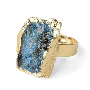 Front view of a blue kyanite ring, showing the stone's vertical striations and irregular gold-tone border.
