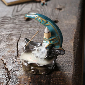 High angled view of the Blue moon incense burner on rough timber, looking into the curved basin and down the sculpted smoke path.