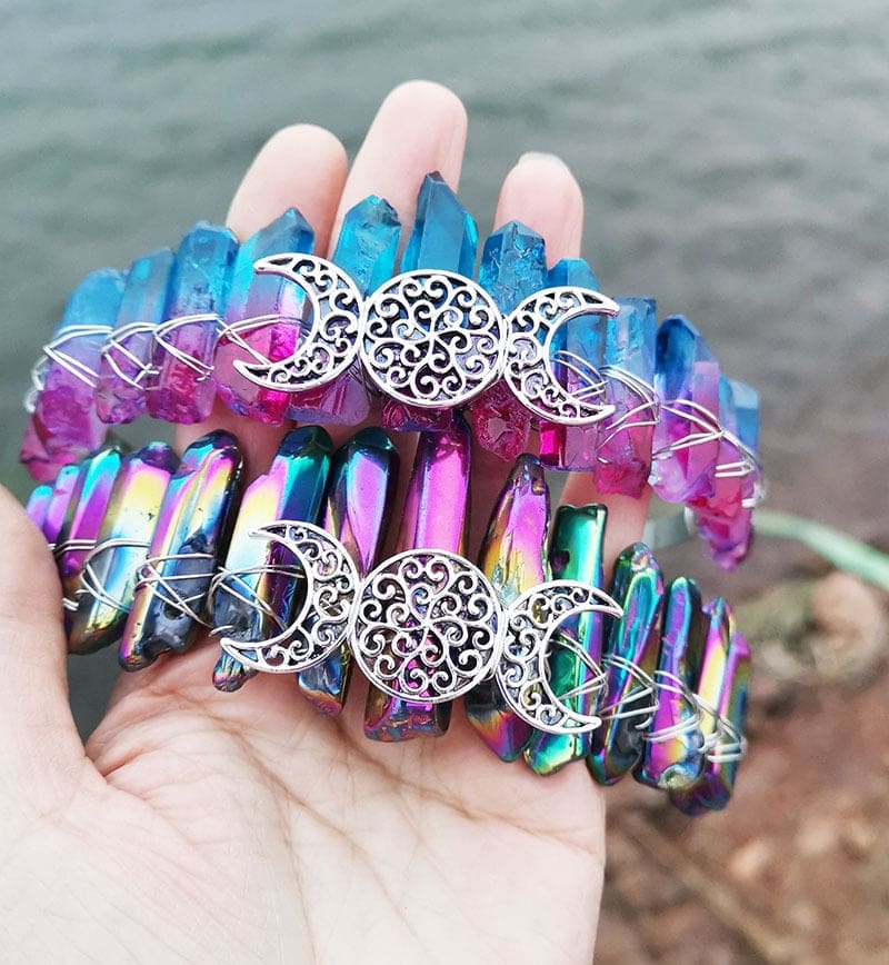 Pair of triple moon crowns with blue-pink and metallic rainbow crystals, shown together to compare the point colours.