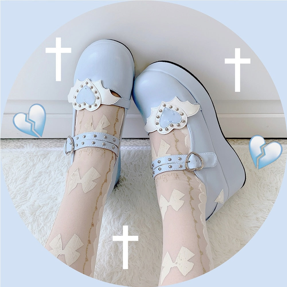 Blue winged-heart Mary Janes worn with sheer patterned stockings, photographed from above against a pale blue graphic background.