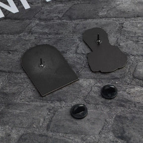 Reverse sides of the two portrait pins on gray fabric, each with one post and a separate black rubber-clutch backing.