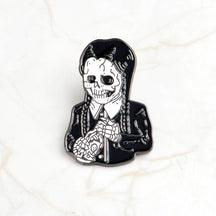 Black-and-white skeleton enamel pin with long braids, a pale shirt collar and dark skirt, isolated on white.
