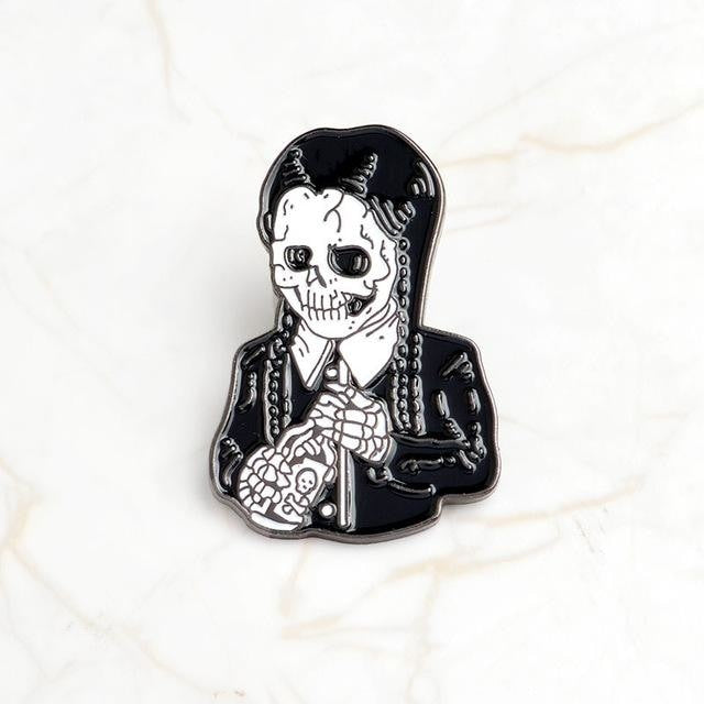 Black-and-white skeleton enamel pin with long braids, a pale shirt collar and dark skirt, isolated on white.