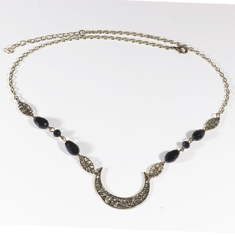 Bronze-tone ornate crescent headdress with large black teardrop beads and small dark accents, arranged in an oval on a pale background with the clasp and chain visible.