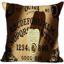 Brown square Ouija cushion cover with black lettering, sun and moon faces and a pale printed planchette drawn to look raised above the board.