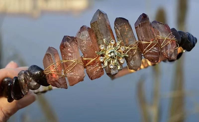 Brown crystal tiara with a gold-tone sun face, warm translucent points and wrapped wire along the band.