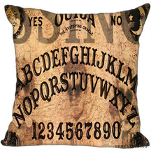 Weathered brown square Ouija cushion cover with large black alphabet arcs, numerals and sun-and-moon corner details.