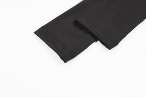 Two black sleeve ends laid together, showing the narrow cuffs and stitched edges of the buckle crop top.
