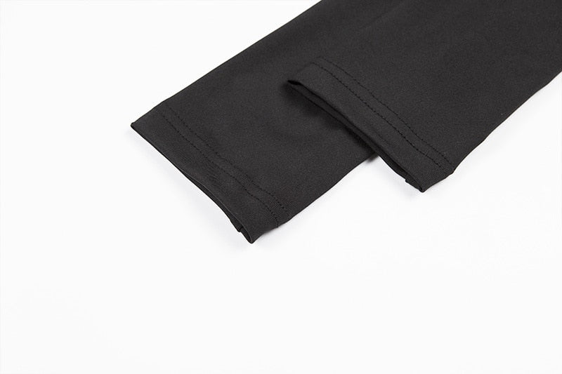 Two black sleeve ends laid together, showing the narrow cuffs and stitched edges of the buckle crop top.