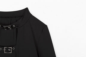 Detail view of the black crop top showing the buckled neck opening, shoulder seam and upper chest strap.