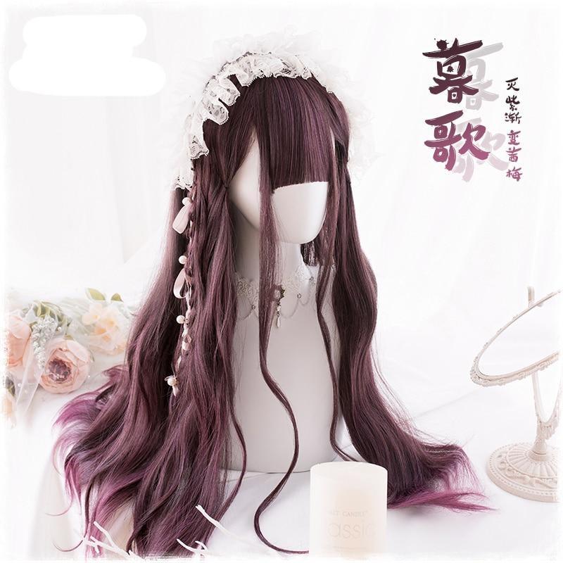 Angled front view of the dark burgundy wig styled with a narrow braid and white lace headpiece. A mirror, flowers and a candle decorate the pale display; supplier lettering overlays the photo.