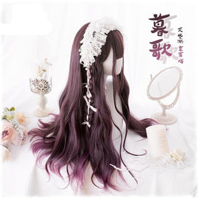Side view of the long burgundy wig, with full bangs, a small braid and a white lace headpiece. Dark red waves fall past the mannequin shoulder beside floral and candle props.