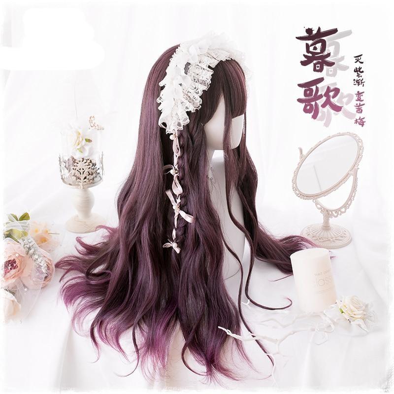 Side view of the long burgundy wig, with full bangs, a small braid and a white lace headpiece. Dark red waves fall past the mannequin shoulder beside floral and candle props.