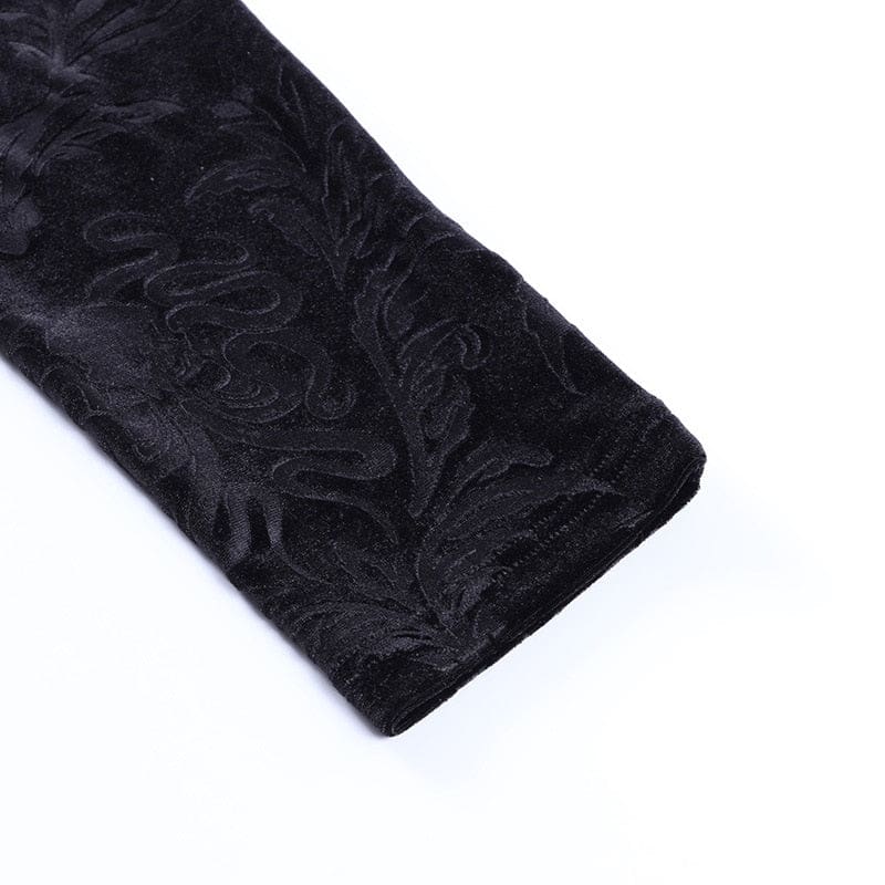 Close-up of a black trouser cuff, showing the serpentine and leaf pattern in the velvet and the stitched hem.