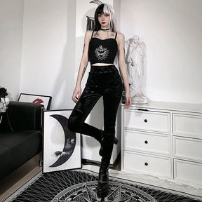 Cameo velvet pants shown standing with one knee bent, emphasizing their high waist and fitted ankle-length shape.