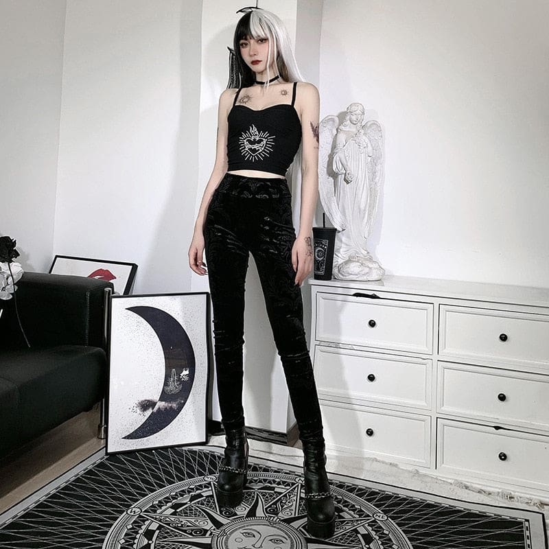 Full-length front view of the black patterned skinny pants, styled with a sun-print crop top and platform footwear.