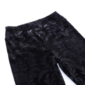 Flat detail of the black patterned velvet pants at the front waistband and upper legs.
