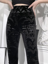 Close front view of black Cameo velvet pants with a high waistband and scrolling botanical and serpentine pattern.