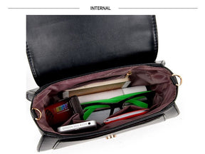 Open black cat-ear purse viewed from above, showing its lining, inner zip pocket and several small objects used to demonstrate the space.