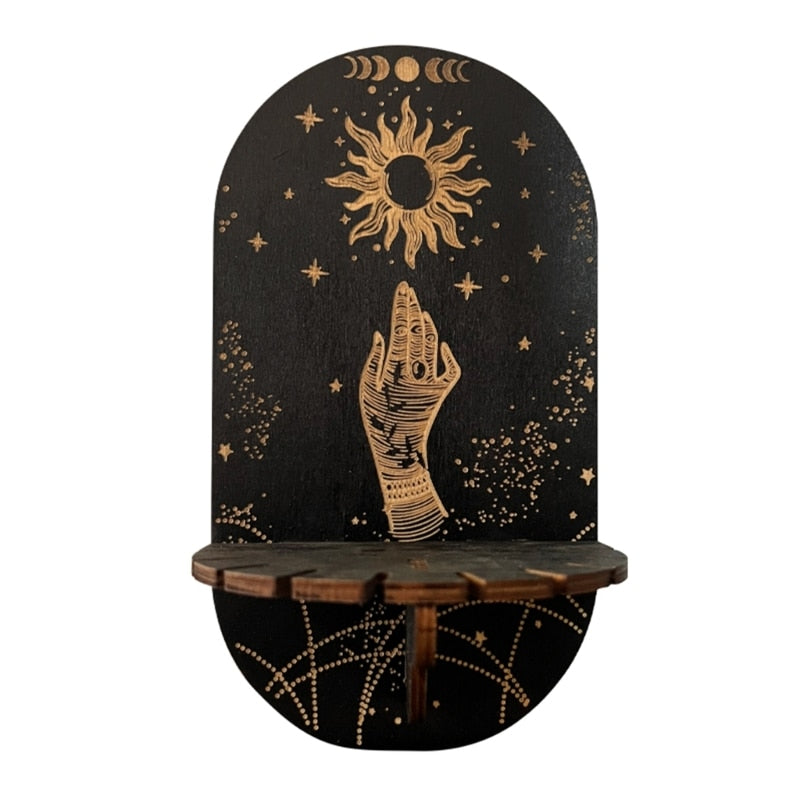 Black wooden display shelf with a gold-tone illustrated hand below a sun and moon phases, with printed chain-like lines beneath the ledge.