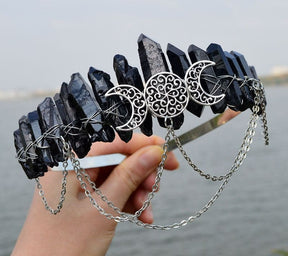 Black pointed crown with a full moon flanked by crescents and loops of silver-tone chain.