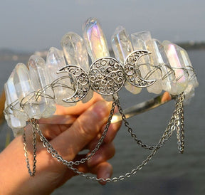Handheld profile of the clear iridescent triple-moon crown and draped chains.