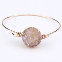 Clear druzy quartz cuff with a pale beige-toned textured face inside a round gold-tone setting.
