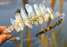 Clear crystal point tiara with a gold-tone sun face and irregular pale points rising above the curved band.
