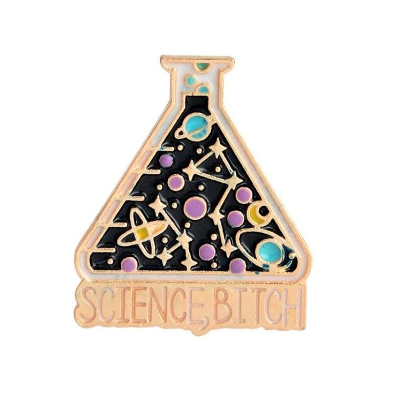 Flask-shaped enamel pin with a black background, gold-tone outlines, colourful planets and stars. The base reads Science, Bitch.