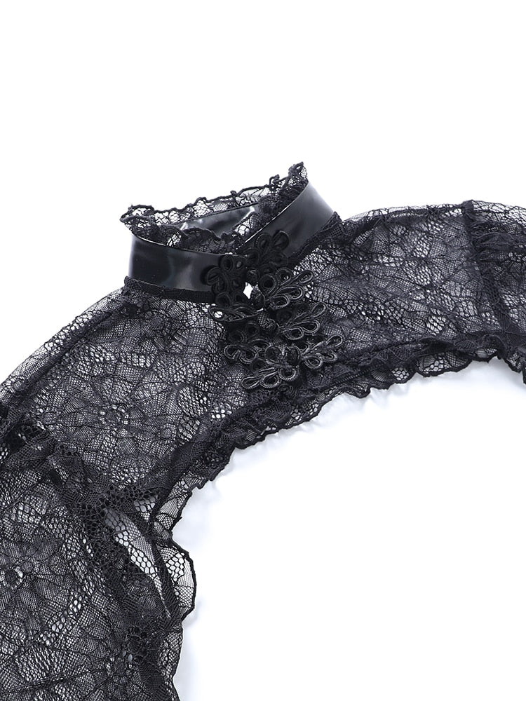 The overlay collar laid flat, showing glossy black trim and clustered ornamental fastenings over sheer lace.