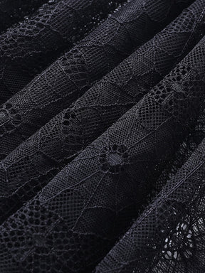 Close-up of the black spiderweb lace gathered into folds, revealing the fine mesh between the web motifs.