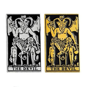 Two rectangular The Devil tarot card pins on white, comparing gold-tone and silver-tone artwork against black.
