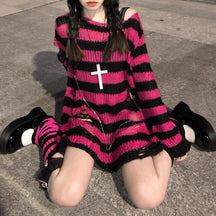 Fuchsia and black striped long sweater worn on a staircase, showing a wide neckline and distressed lower front. It is styled with striped socks and dark accessories.