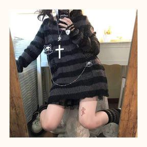 Fuller mirror view of a long grey and black striped sweater worn over a short black skirt, with one knee bent and a chain across the front.