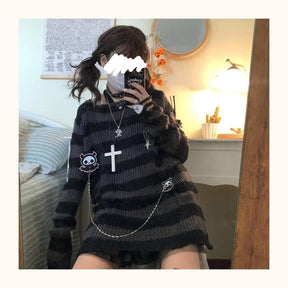 Grey and black long sweater worn in a bedroom mirror photo, showing its wide neckline, long sleeves and distressed knit near the lower side.