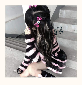 Side and rear styling view of a pink and black striped sweater on a staircase, with long dark hair, pink clips and a matching ribbon-trim skirt.