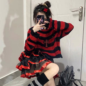 Red and black striped cropped sweater worn with a black-and-red ruffled skirt. The model sits for a mirror photo with one arm raised behind the head.