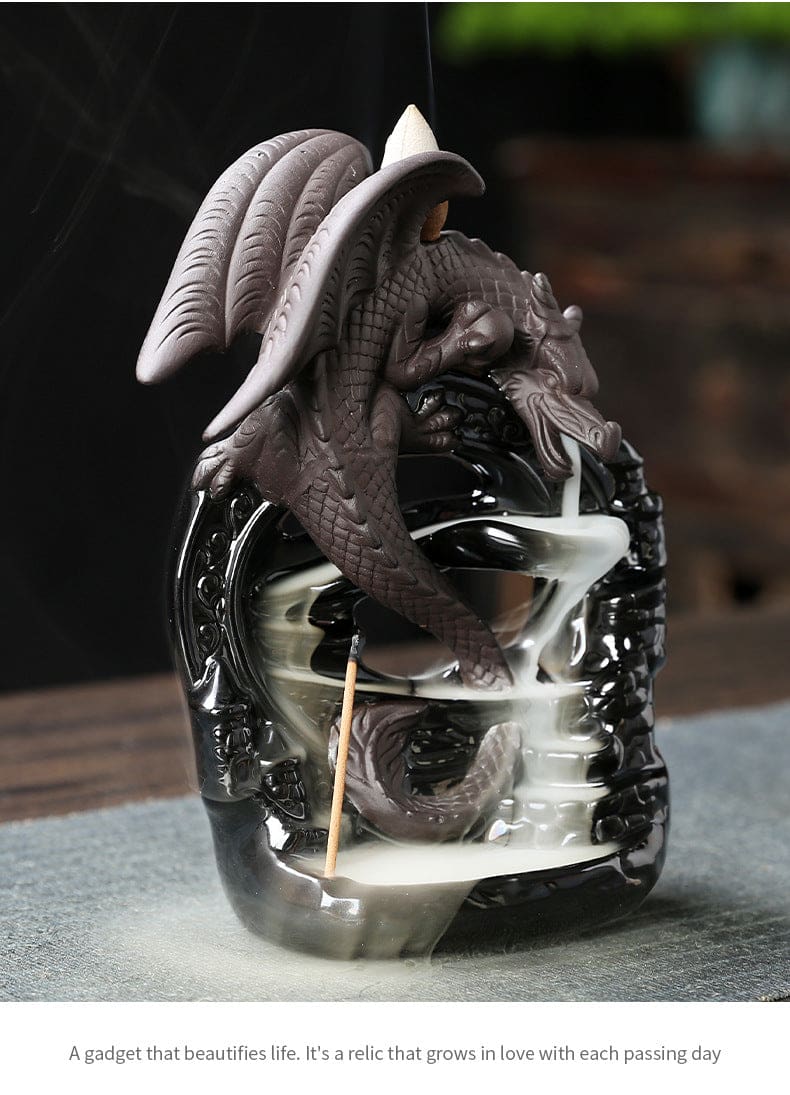 Angled view of the gray dragon burner with its curling tail inside the black arch, a descending smoke trail and a small promotional caption beneath the photo.
