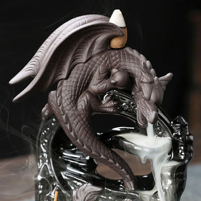 Repeated close view of the dragon burner’s head and raised wings, with the backflow cone behind the wings and smoke below the mouth.