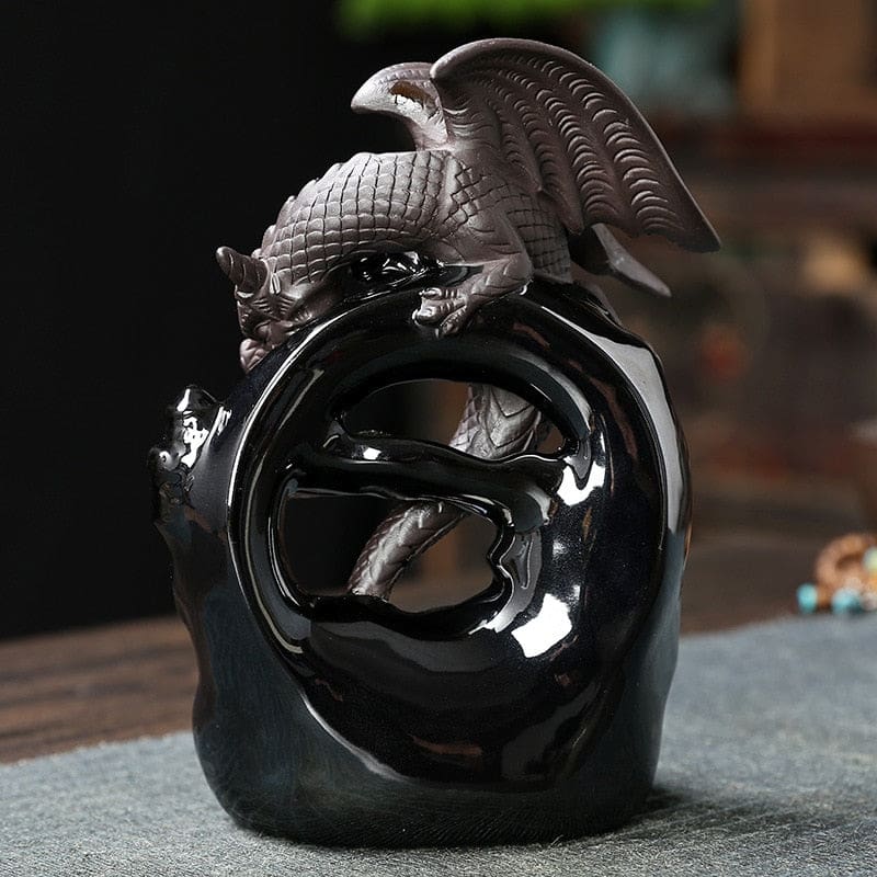 Square rear view of the dragon incense burner, showing the open circular arch, glossy black surface and tail visible through the centre.