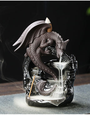 Full view of the dragon incense burner on a fabric-covered tabletop, showing the entire smoke trail from the mouth to the broad lower pool.