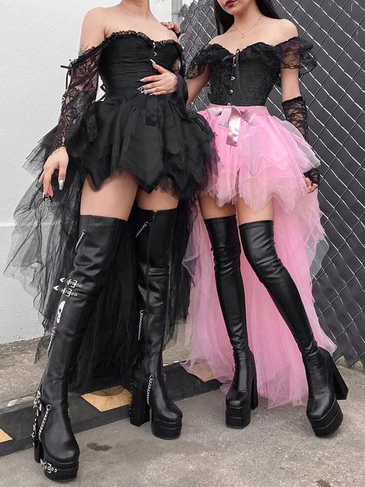 Two models wear black and pink layered tutu skirts by a metal fence, showing the short fronts and longer pointed mesh layers with chunky boots.